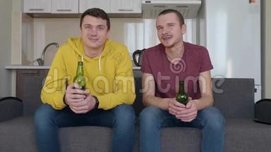 两个人坐在沙发上，看电视上的<strong>足球赛</strong>，喝啤酒
